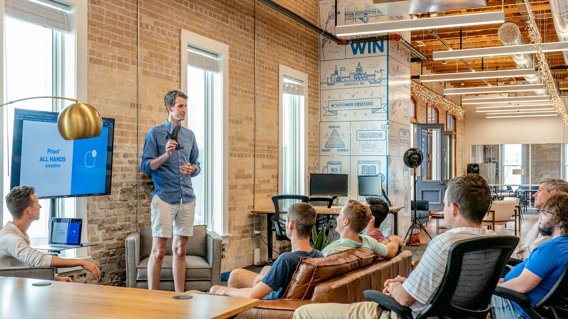 A man stands in front of a group of people, giving a presentation.